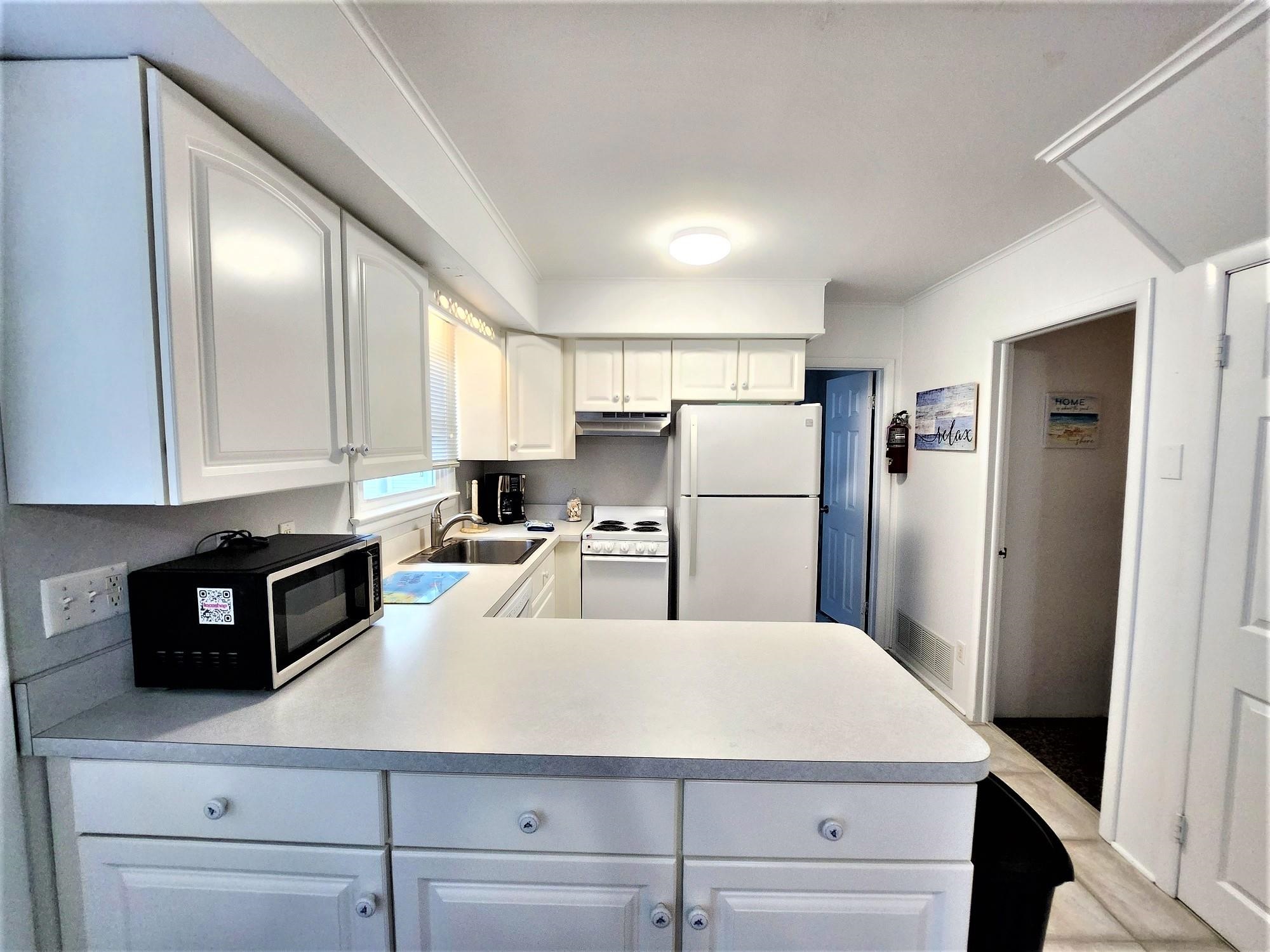 9903 2nd Stone Harbor, NJ 08247 - Photo 10 of 28 a kitchen with refrigerator and cabinets