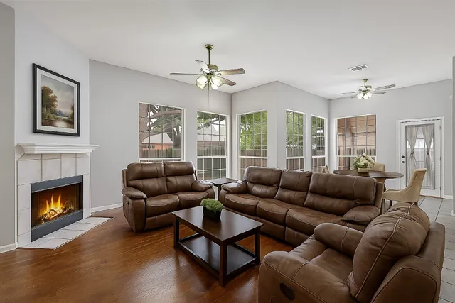 a living room with furniture a fireplace and a large window