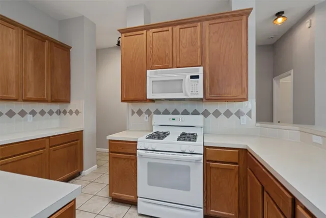 a kitchen with granite countertop white cabinets and white appliances
