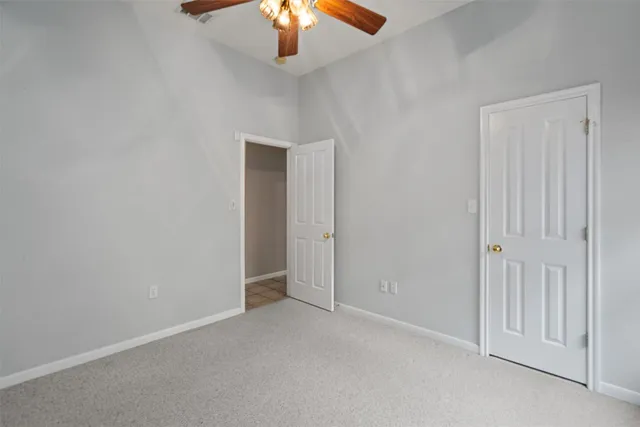 an empty room with a chandelier fan