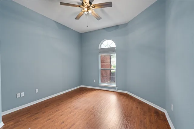 an empty room with a window and wooden floor