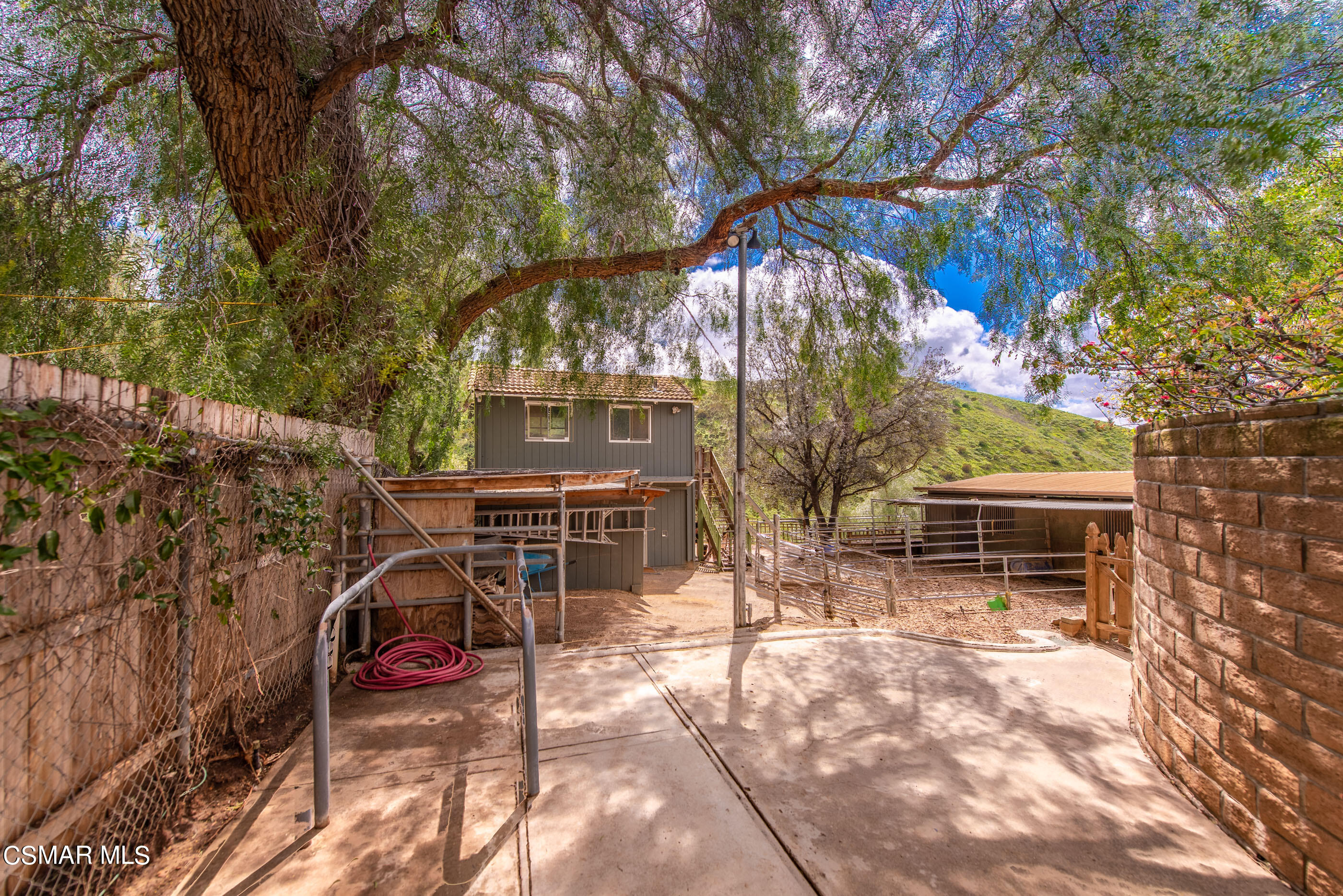 1216 Rambling Road Simi Valley, CA 93065 - Photo 54 of 88 a view of a patio with table and chairs with wooden fence and plants