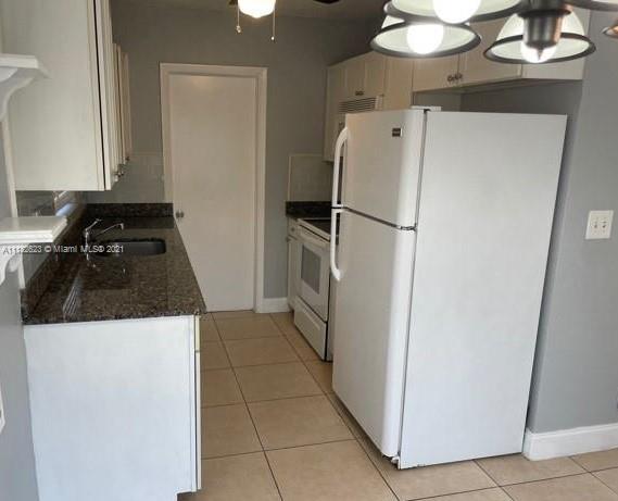 a white refrigerator freezer and a stove sitting inside of a kitchen