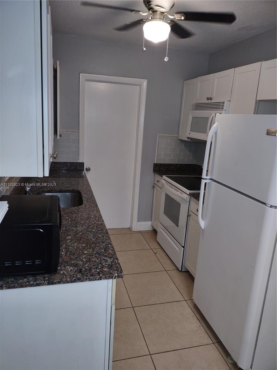 Avondale Pompano Beach, FL 33060 - Photo 3 of 18 a kitchen with a refrigerator and a stove top oven