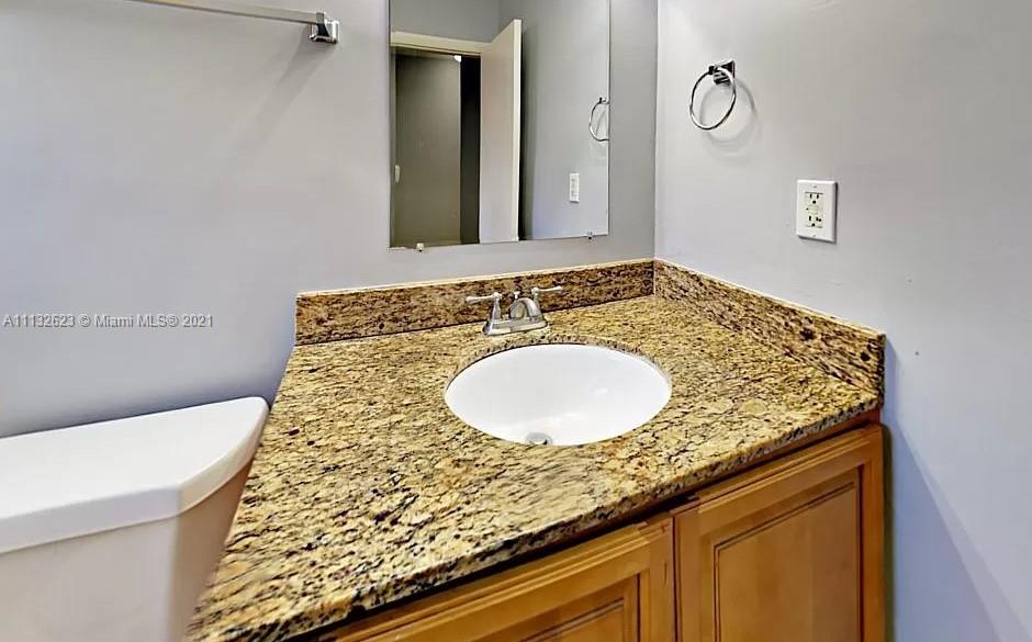 Avondale Pompano Beach, FL 33060 - Photo 9 of 18 a bathroom with a granite countertop sink and a mirror