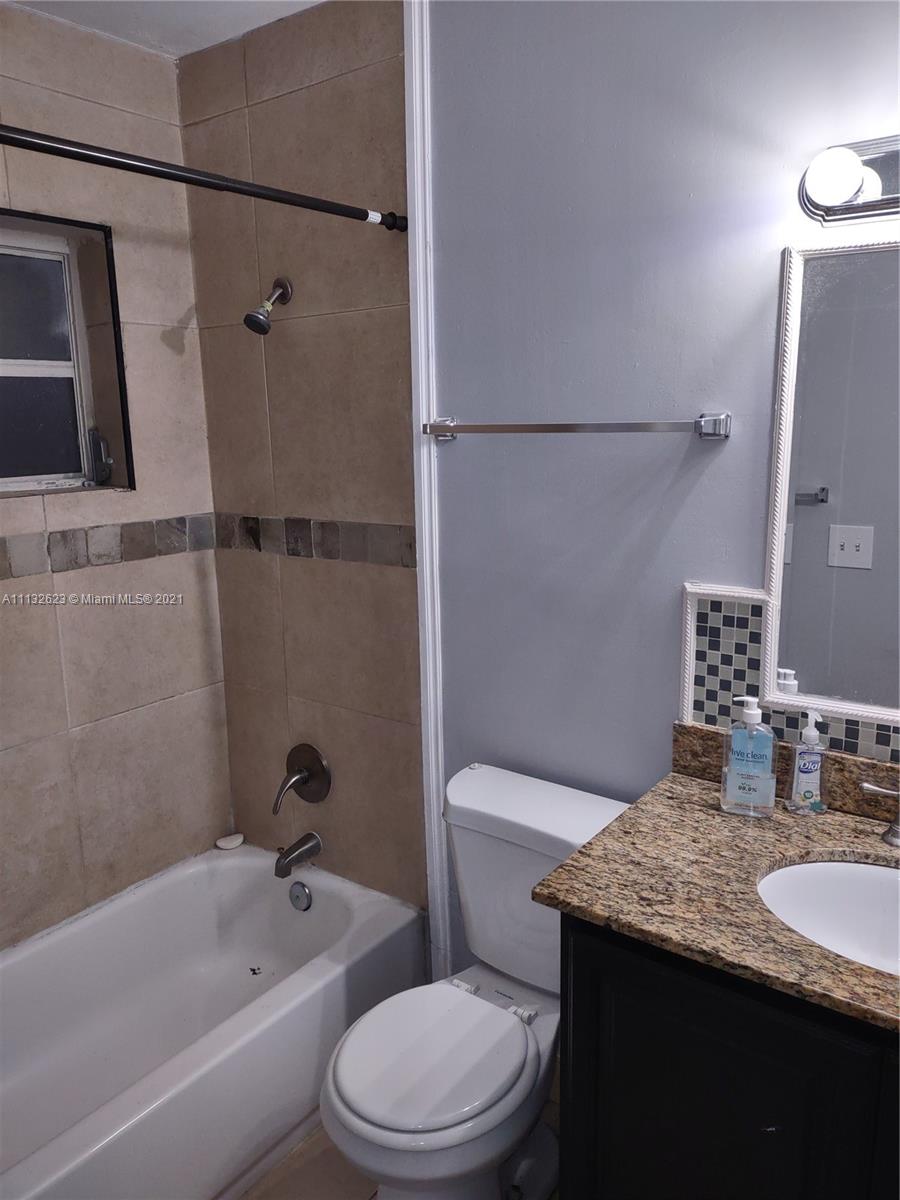 Avondale Pompano Beach, FL 33060 - Photo 10 of 18 a bathroom with a granite countertop bathtub shower sink vanity and toilet