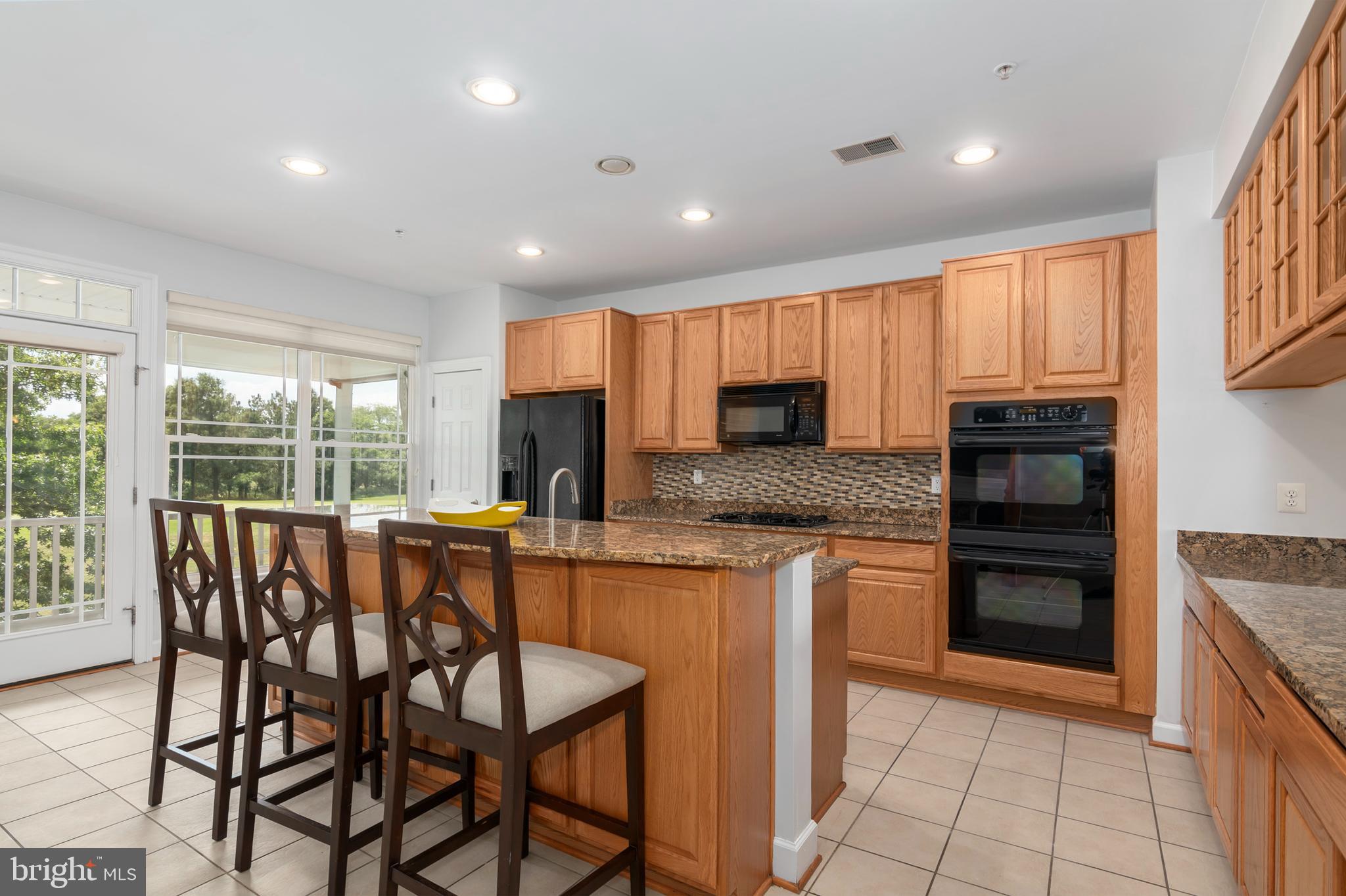2804 Persimmon Place, Unit D3 Cambridge, MD 21613 - Photo 18 of 49 a kitchen with stainless steel appliances granite countertop a stove top oven a sink and a refrigerator