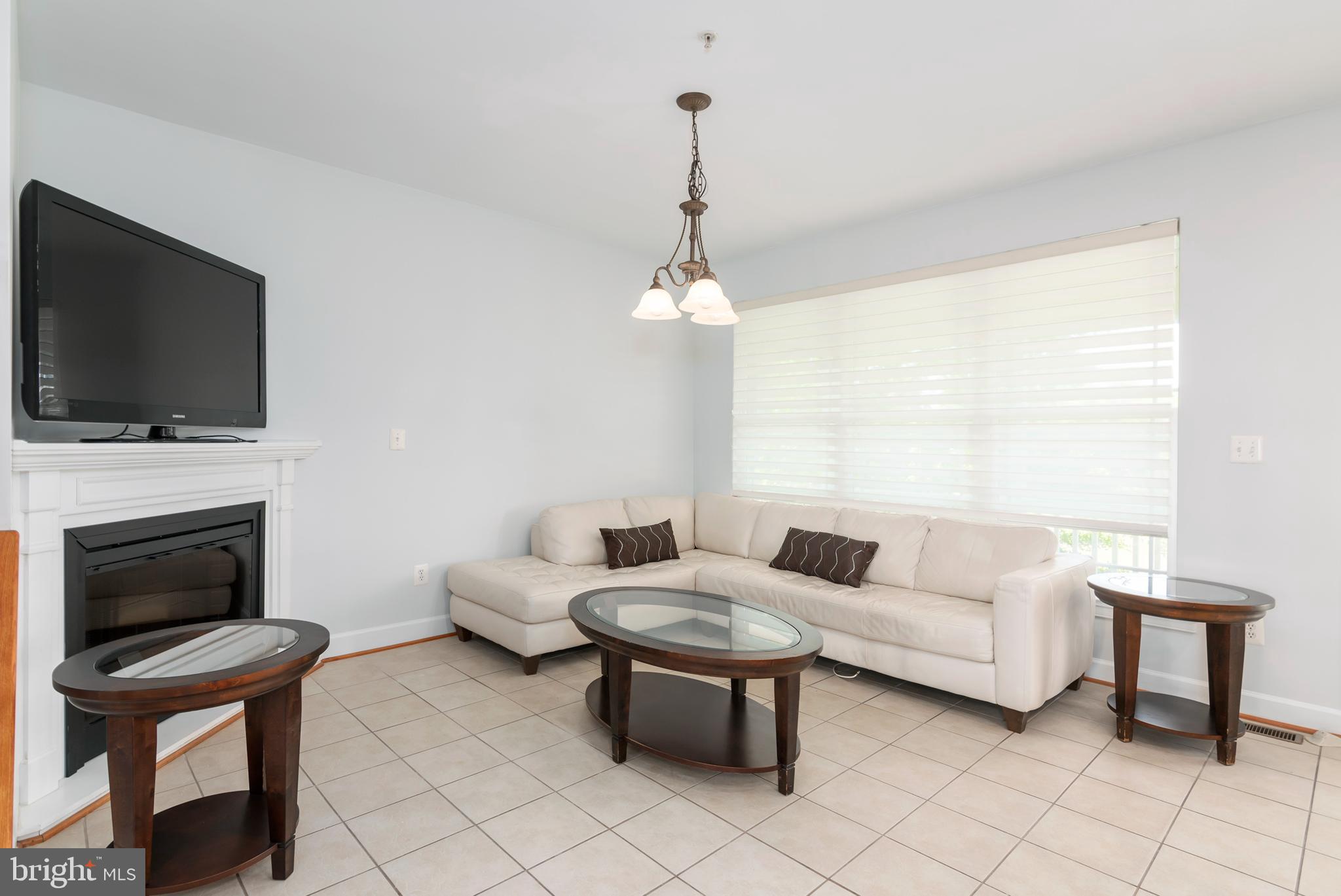 2804 Persimmon Place, Unit D3 Cambridge, MD 21613 - Photo 20 of 49 a living room with furniture a fireplace and a flat screen tv