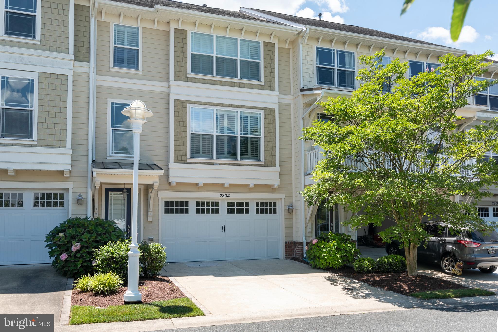 2804 Persimmon Place, Unit D3 Cambridge, MD 21613 - Photo 21 of 49 a front view of a building with a garden and plants