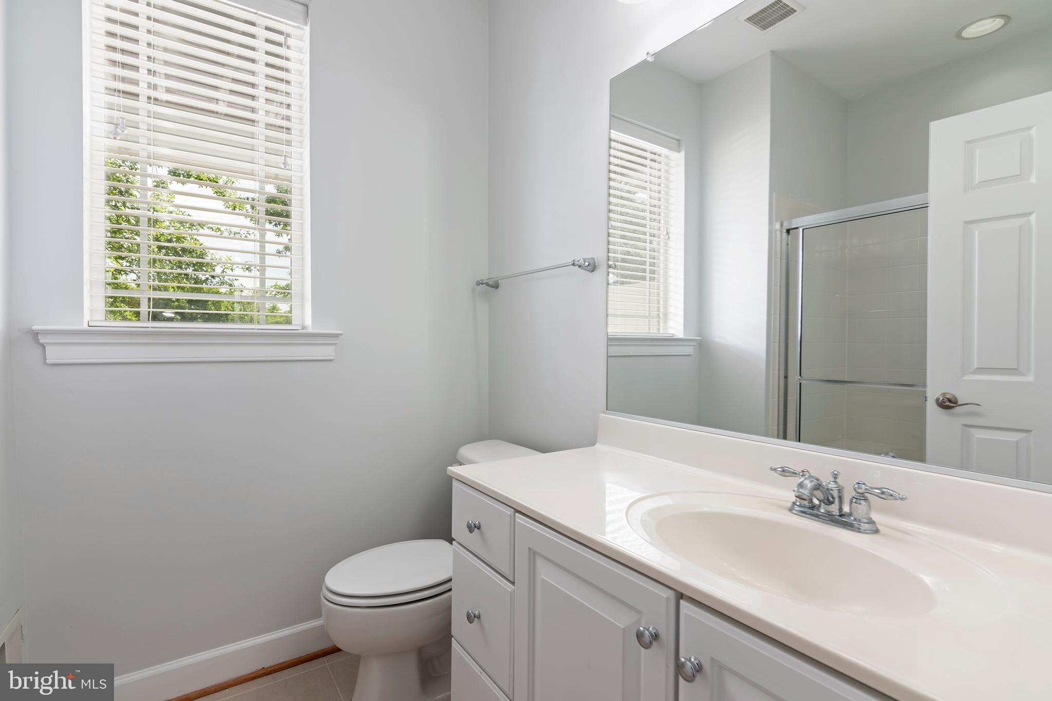 2804 Persimmon Place, Unit D3 Cambridge, MD 21613 - Photo 41 of 49 a bathroom with a granite countertop toilet a sink and a mirror