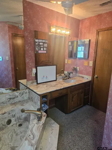 a room with a table chairs sink and wooden floor