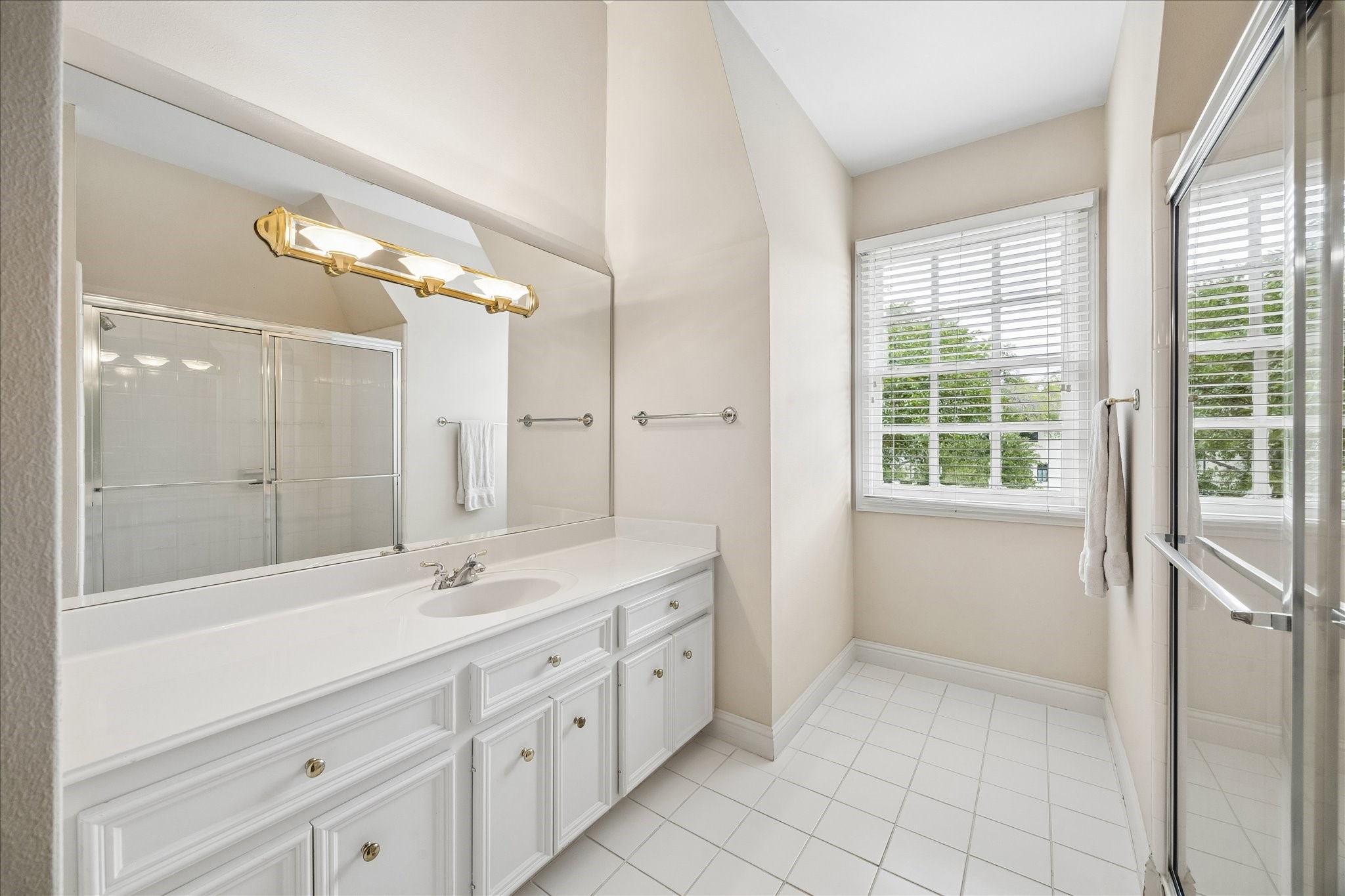 11421 Whippoorwill Road Houston, TX 77024 - Photo 23 of 33 a spacious bathroom with a double vanity sink a large mirror and shower