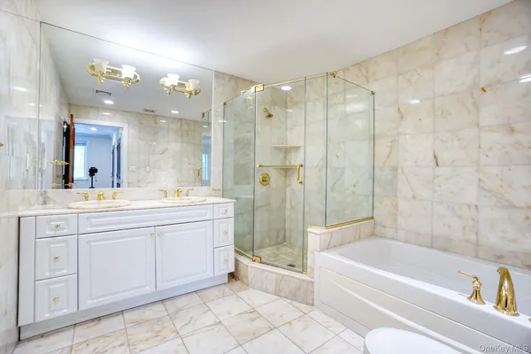 a bathroom with a tub a sink shower and mirror