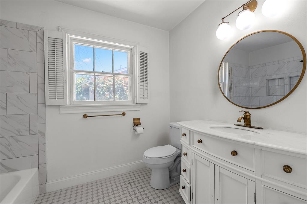 3225 Windsor Avenue Waco, TX 76708 - Photo 14 of 25 Bathroom featuring a white vanity with integrated sink, a circular mirror, and overhead vanity lighting