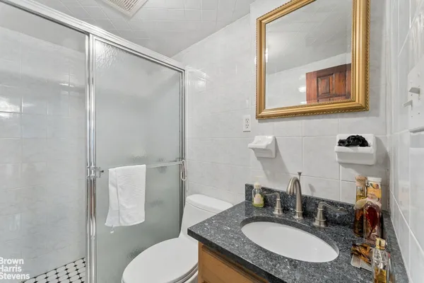 a bathroom with a granite countertop sink toilet and shower