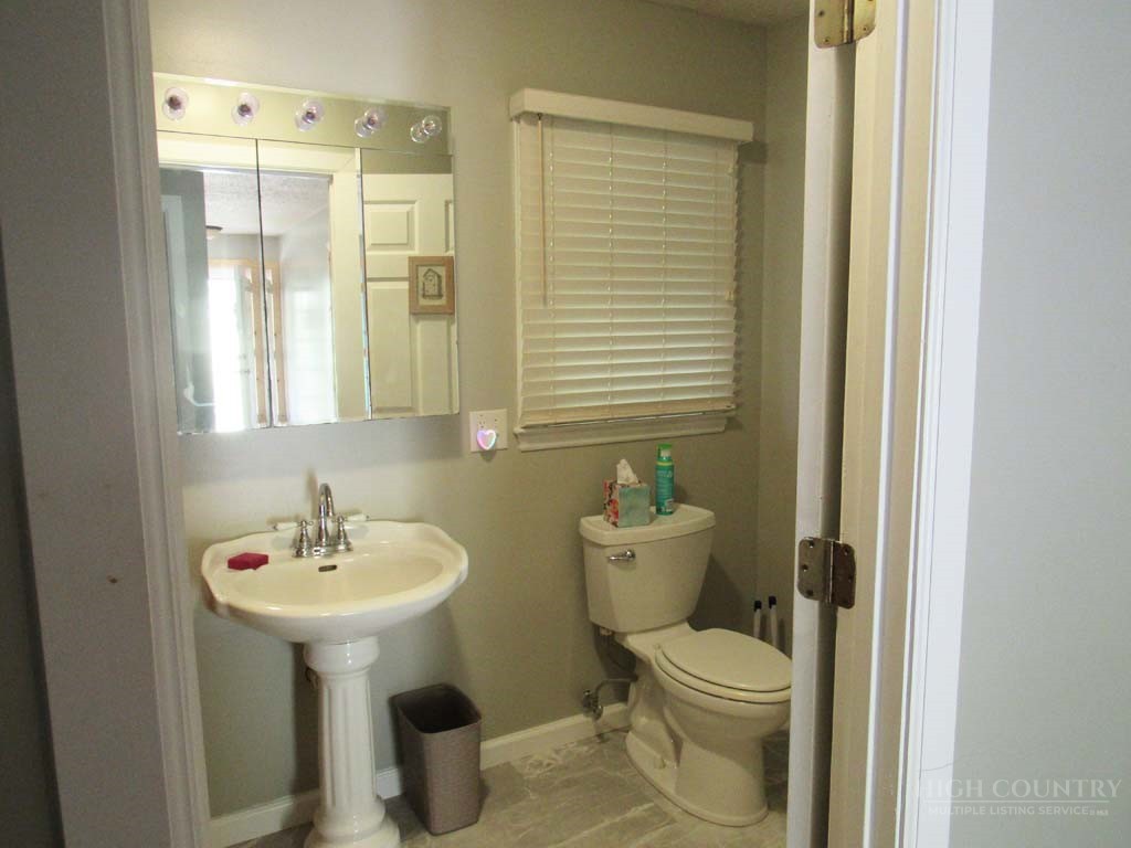 805 Ed Little Road Warrensville, NC 28693 - Photo 33 of 49 a bathroom with a toilet sink and mirror