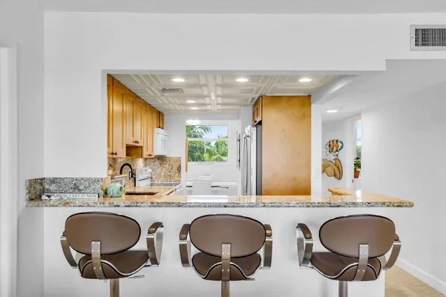 a bathroom with a granite countertop double vanity and a mirror