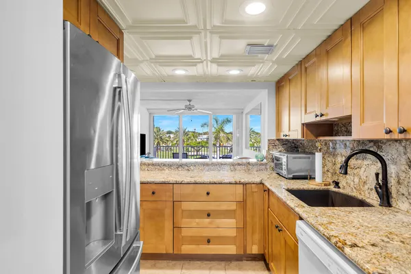 a kitchen with granite countertop a sink stainless steel appliances and cabinets