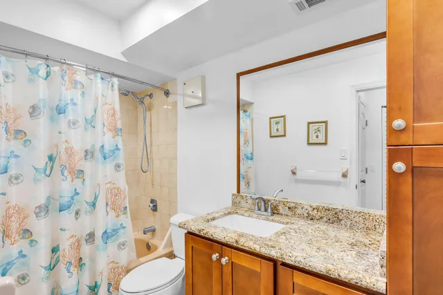 a bathroom with a granite countertop sink toilet and shower