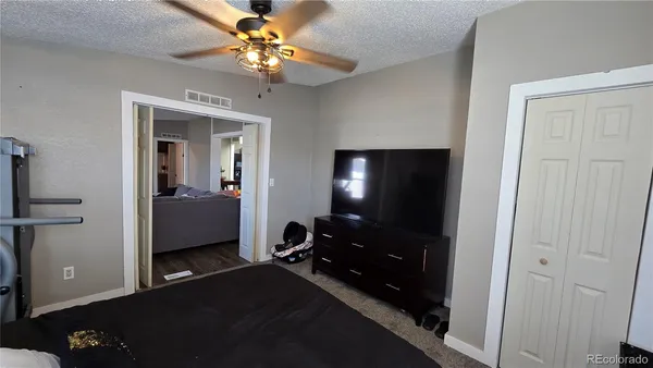 a view of a livingroom with a chandelier fan and a bathroom
