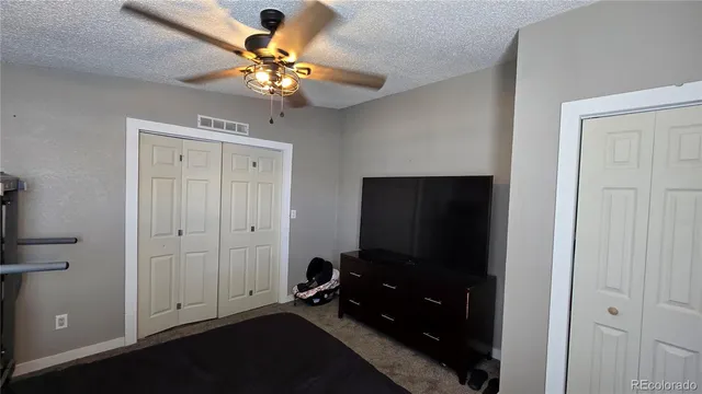 a room with chandelier fan and wooden floor