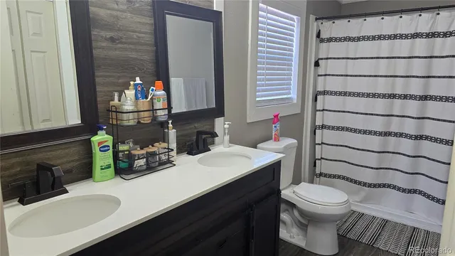 a bathroom with a sink a toilet and shower curtain