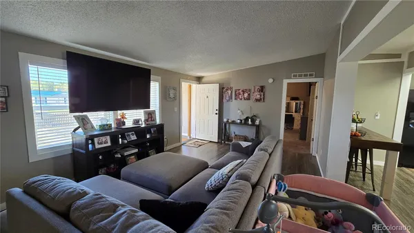 a living room with furniture a flat screen tv and a window