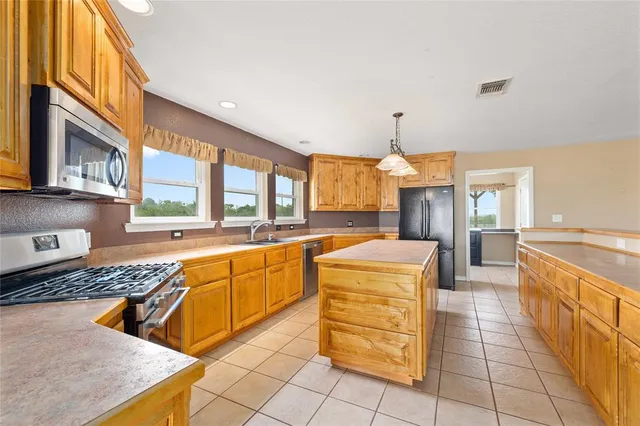 a large kitchen with stainless steel appliances granite countertop a sink and cabinets