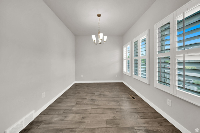 7817 West Kings Top Road Magna, UT 84044 - Photo 4 of 29 Formal Dining Area Wood-finish flooring with a neutral wall color, recessed lighting, and a multi-bulb chandelier