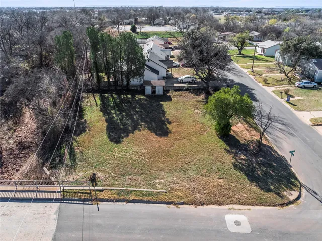 a view of a yard with wooden fence
