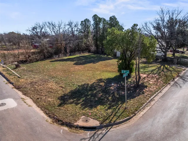 a view of a backyard with wooden fence