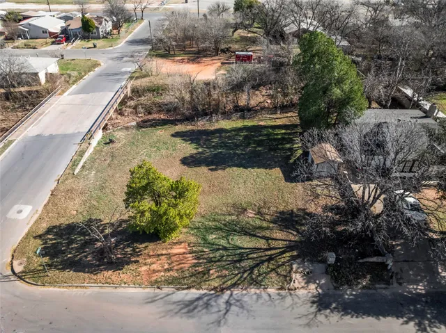 a view of a yard with wooden fence