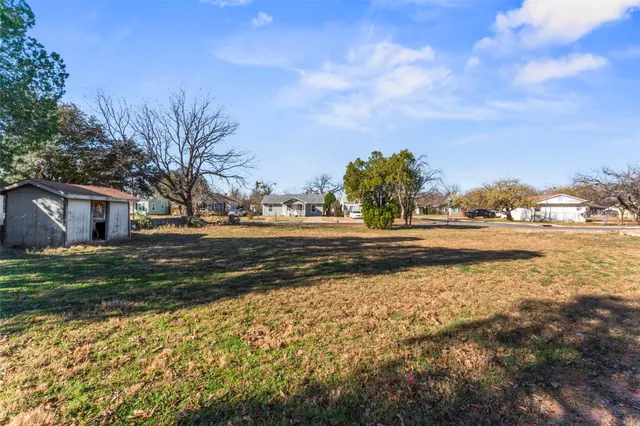 a view of dirt yard with green space