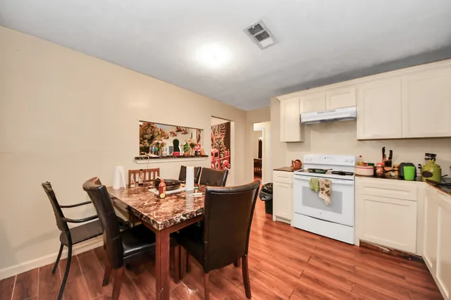 a kitchen with a dining table chairs and white cabinets