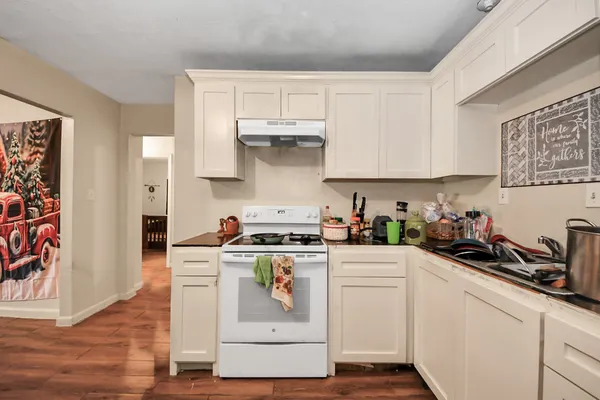 a kitchen with white cabinets and appliances