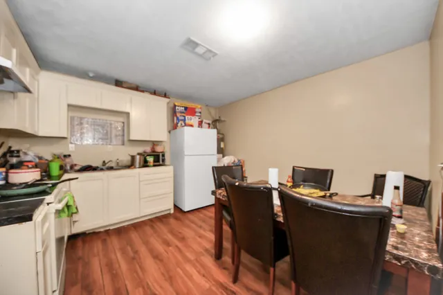 a kitchen with a table chairs refrigerator and microwave