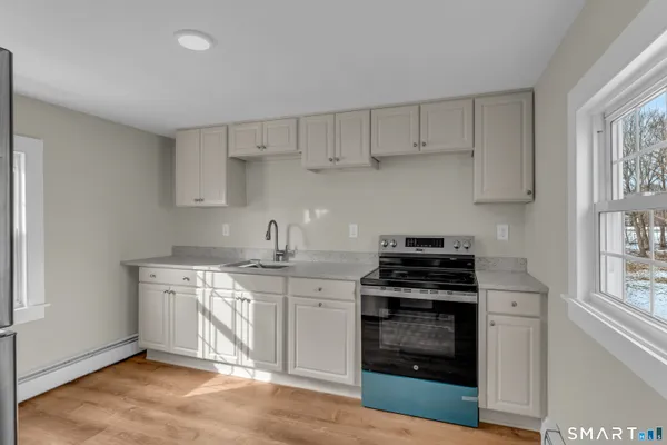 a kitchen with appliances a sink and cabinets