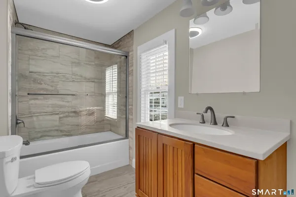 a bathroom with a sink a toilet and shower