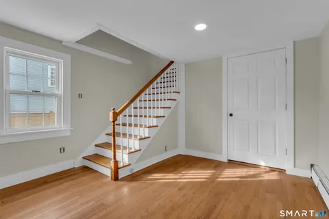 a view of front door with wooden floor and stairs