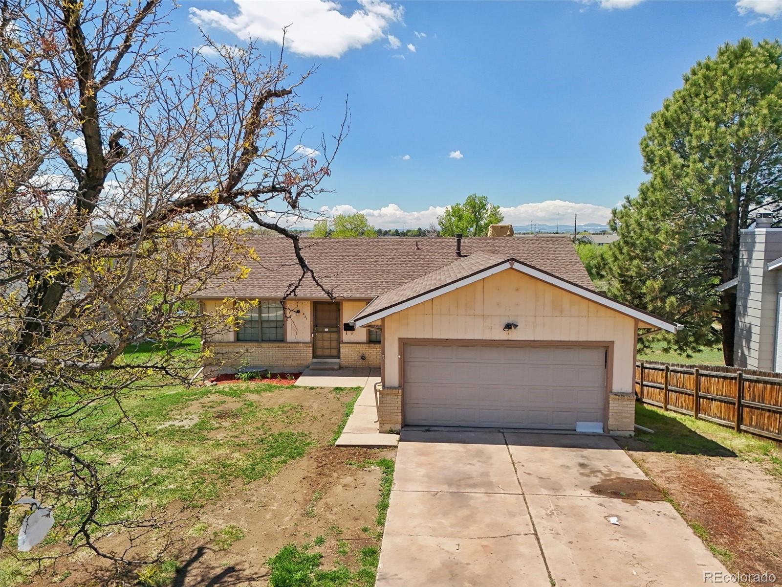 831 Sable Boulevard Aurora, CO 80011 - Photo 2 of 50 a front view of a house with a yard and garage