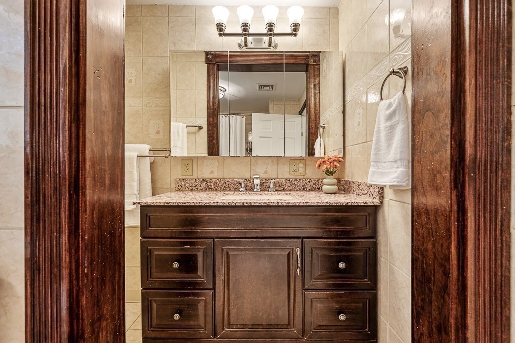194 Paine Street Bellingham, MA 02019 - Photo 20 of 28 a bathroom with a granite countertop sink and a mirror