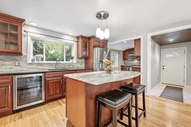 a open kitchen with stainless steel appliances granite countertop a stove and a wooden floors