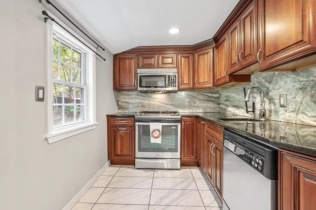a kitchen with stainless steel appliances granite countertop a stove sink and cabinets