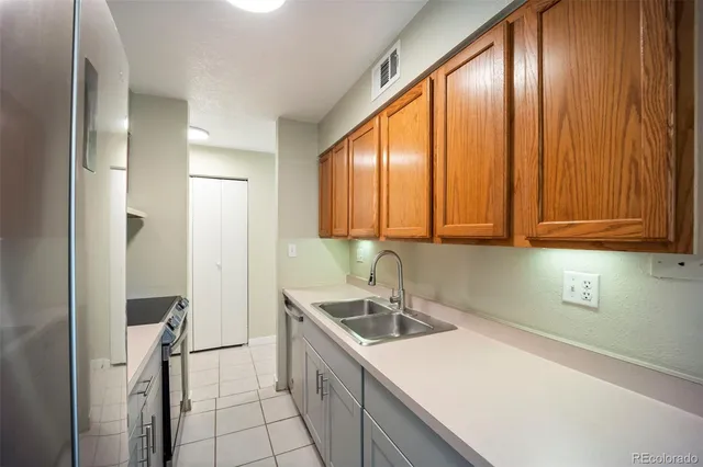 a kitchen with a sink a refrigerator and cabinets