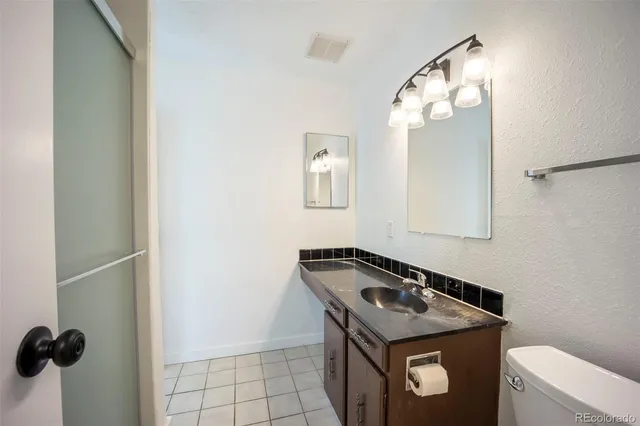 a bathroom with a granite countertop sink and a washing machine