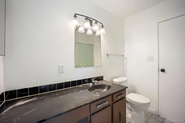 a bathroom with a sink a toilet and mirror