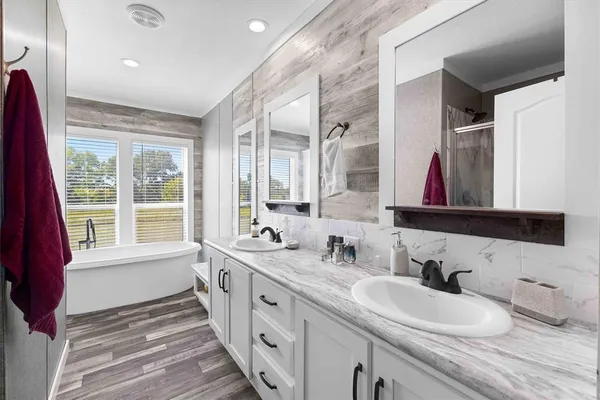 a bathroom with double vanity sinks a mirror and a window