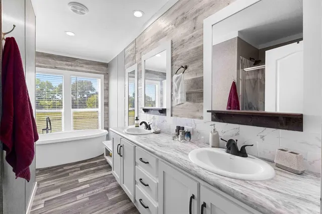 a bathroom with double vanity sinks a mirror and a window