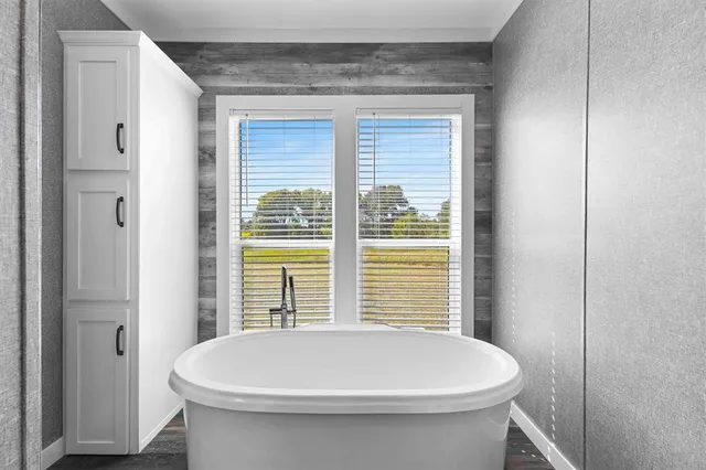 a bathroom with a white toilet and a window