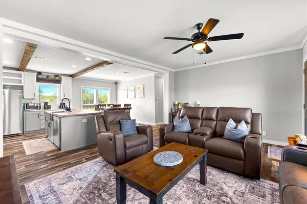 a living room with furniture kitchen view and a window